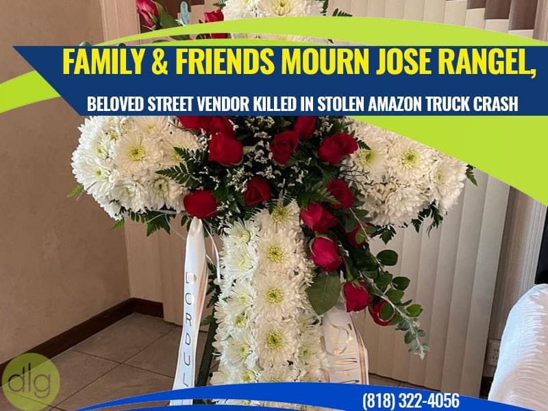 A white floral cross with red roses stands indoors, accompanied by a condolence ribbon, as part of a memorial for Jose Rangel.