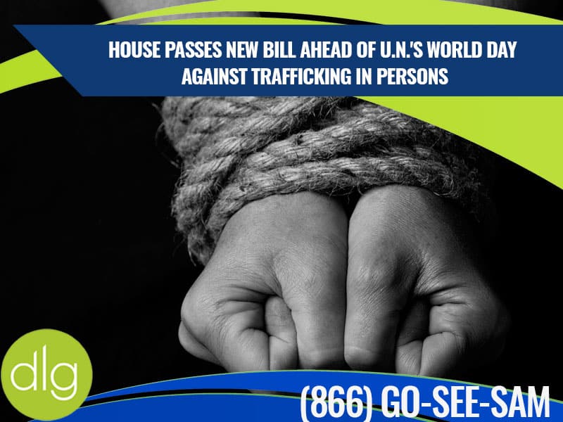 A pair of hands tied together with rope, with a headline about a new bill passed ahead of the U.N.'s World Day Against Trafficking in Persons and a helpline number.