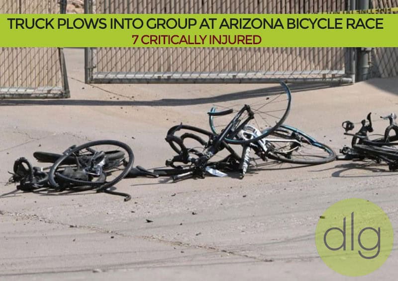 Several damaged bicycles lie on the ground near a fence, following an incident at an Arizona bicycle race where a truck struck participants.