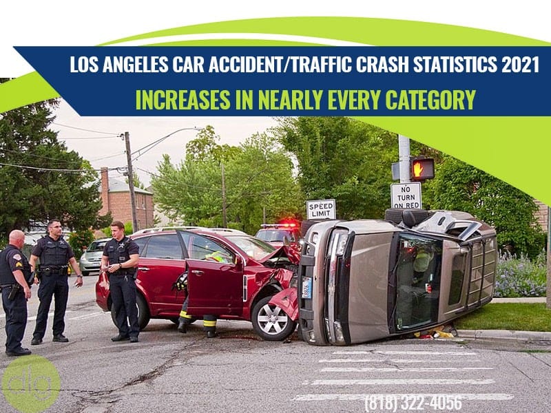 Two cars involved in a traffic accident at an intersection with police officers on scene; one car is flipped onto its side.