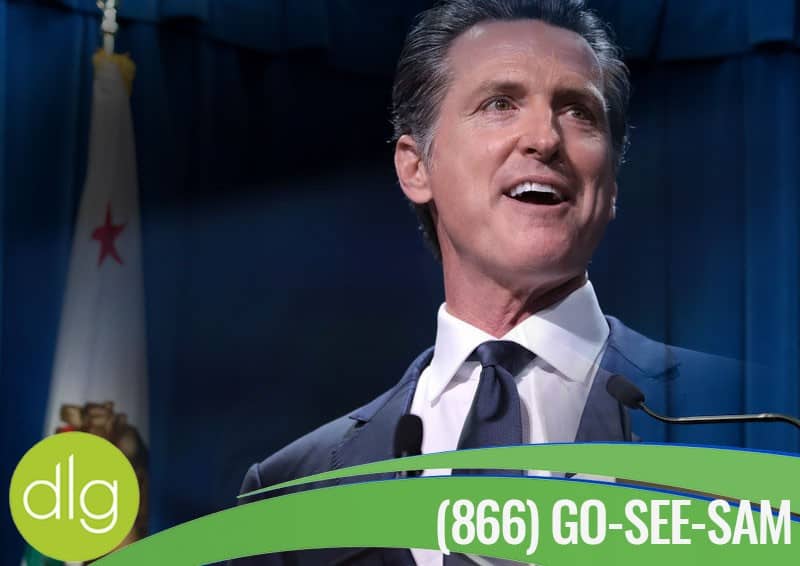 A man in a suit speaks at a podium, with a California state flag in the background and a green banner displaying “(866) GO-SEE-SAM” at the bottom.